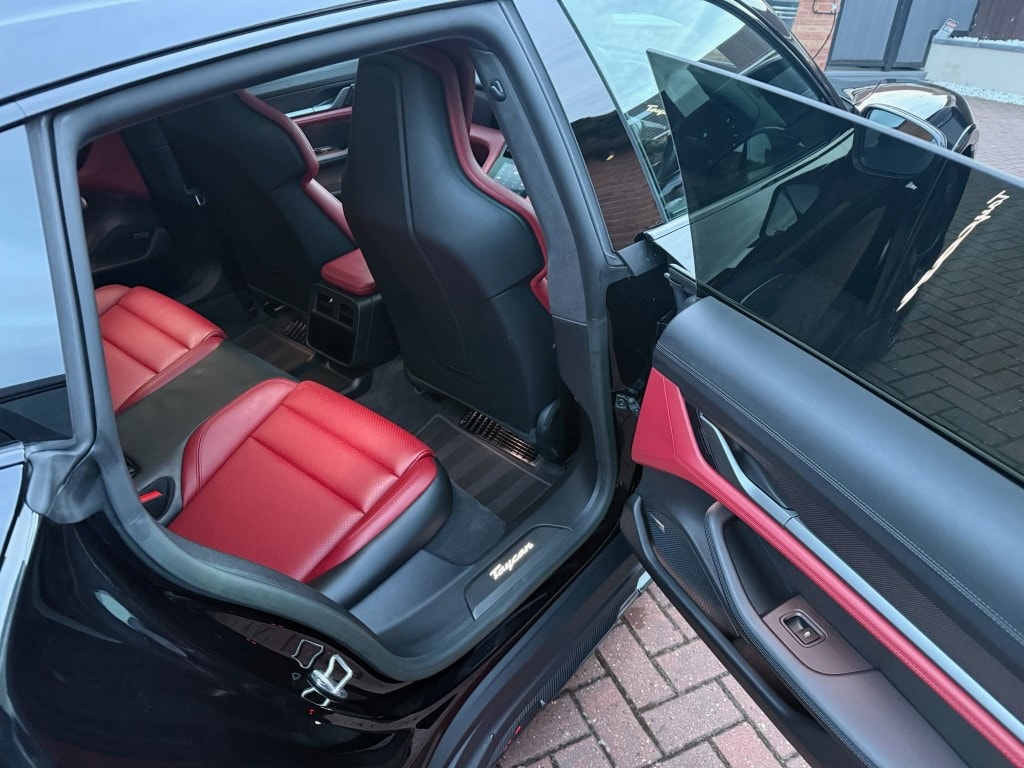 Porsche Taycan rear interior — red leather seats professionally cleaned and refreshed after Signature Valet