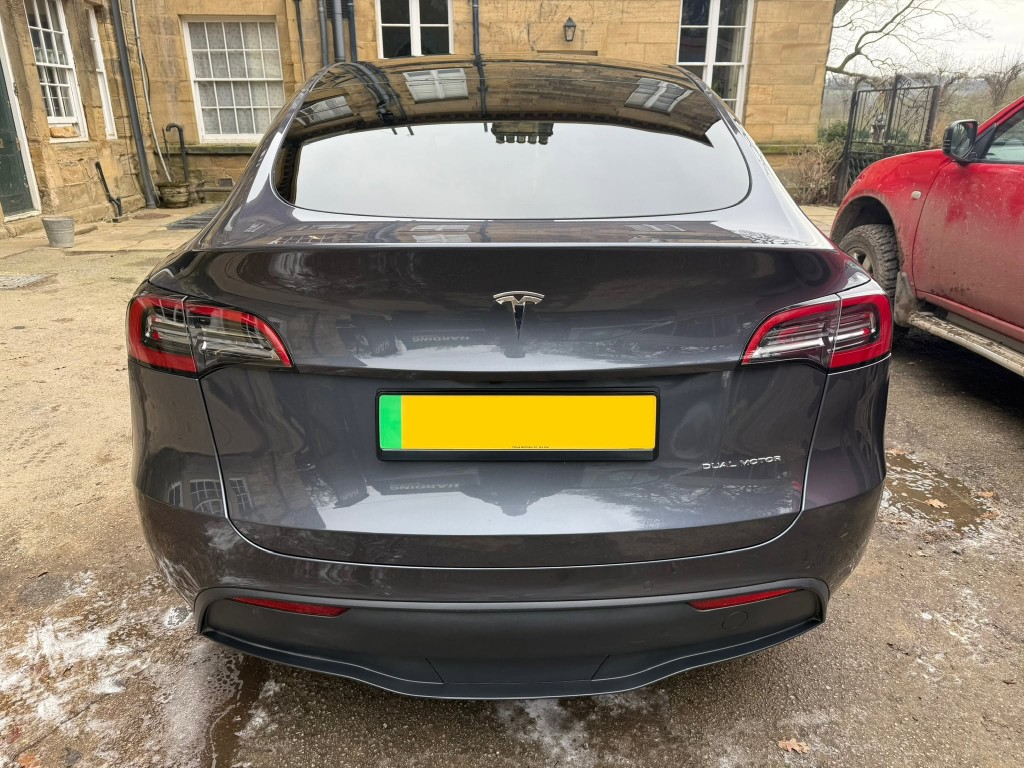 Tesla Model Y after — gloss and presentation enhanced, clean panels with clear reflections